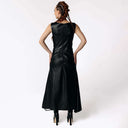 Back view of Caitlin wearing the Kalma Cactus Leather Maxi Dress, a full-length black leather dress that flares out from the hips from SCATHED's Fall Winter 2025 Reaper collection.