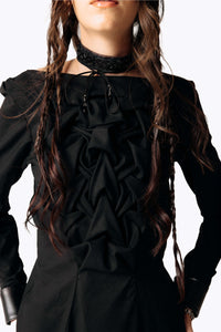 Close-up frontal view of Eliza wearing the Mors Black Cotton Dress with ruffling in the chest and a black choker from SCATHED's Fall Winter 2025 Reaper collection while placing hands on hips.