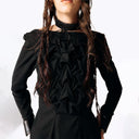 Close-up frontal view of Eliza wearing the Mors Black Cotton Dress with ruffling in the chest and a black choker from SCATHED's Fall Winter 2025 Reaper collection while placing hands on hips.