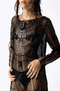 Frontal close-up view of Eliza wearing the Morta Beaded Cross Fringe Dress featuring beaded embellishments and sheer layered with fringe from SCATHED's Fall Winter 2025 Reaper collection.