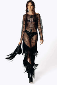 Frontal portrait view of Eliza wearing the Morta Beaded Cross Fringe Dress featuring beaded embellishments and sheer layered with fringe and carrying the fringed Veilwalker Handbag from SCATHED's Fall Winter 2025 Reaper collection walking towards the frame.