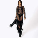 Frontal portrait view of Eliza wearing the Morta Beaded Cross Fringe Dress featuring beaded embellishments and sheer layered with fringe and carrying the fringed Veilwalker Handbag from SCATHED's Fall Winter 2025 Reaper collection walking towards the frame.