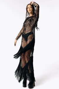 Front view of Eliza wearing the Morta Beaded Cross Fringe Dress featuring beaded embellishments and sheer layered with fringe from SCATHED's Fall Winter 2025 Reaper collection while swaying her hips to create motion in the fringe.