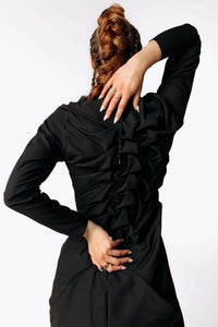 Close-up back view of Caitlin with braided hair wearing the Nox Black Cotton Skeleton Dress with a ruffled spinal texture from SCATHED's Fall Winter 2025 Reaper collection.