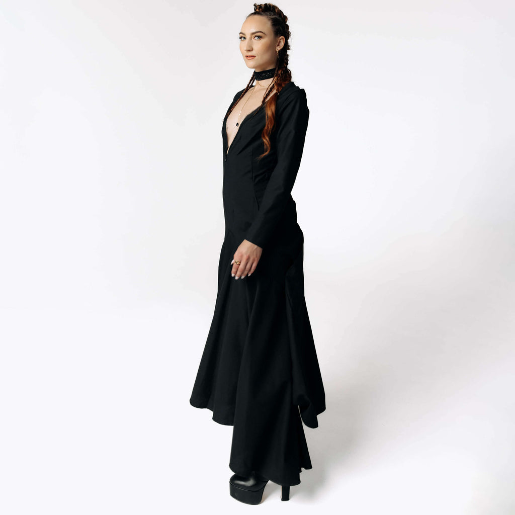 Side view of Caitlin facing camera while wearing the Nox Black Cotton Skeleton Dress with a plunging neckline from SCATHED's Fall Winter 2025 Reaper collection.