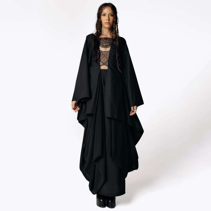 Frontal view of Eliza facing camera while wearing the Reaper Back Winged Gown with intricate hand-beading on the chest and back of the dress from SCATHED's Fall Winter 2025 Reaper collection.