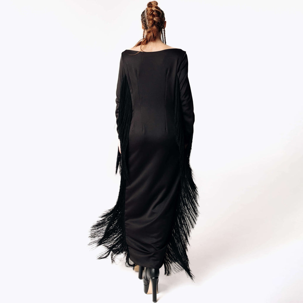 Back view of Caitlin wearing the Revenant Black Dress with fringed sleeves and hem from SCATHED's Fall Winter 2025 Reaper collection.