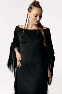 Frontal portrait view of Caitlin  wearing the Revenant Black Dress with fringed sleeves and a high thigh-slit from SCATHED's Fall Winter 2025 Reaper collection.