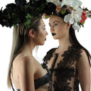 Two women wearing Queen of the Night Lace Dresses from SCATHED's SS25 Gothic Garden collection with floral headpieces