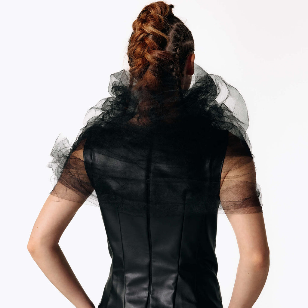 Close-up back view of Caitlin wearing the Wraith Collar, a sheer black tulle shoulder shrug, with the Kalma Cactus Leather Maxi Dress from SCATHED's Fall Winter 2025 Reaper collection.