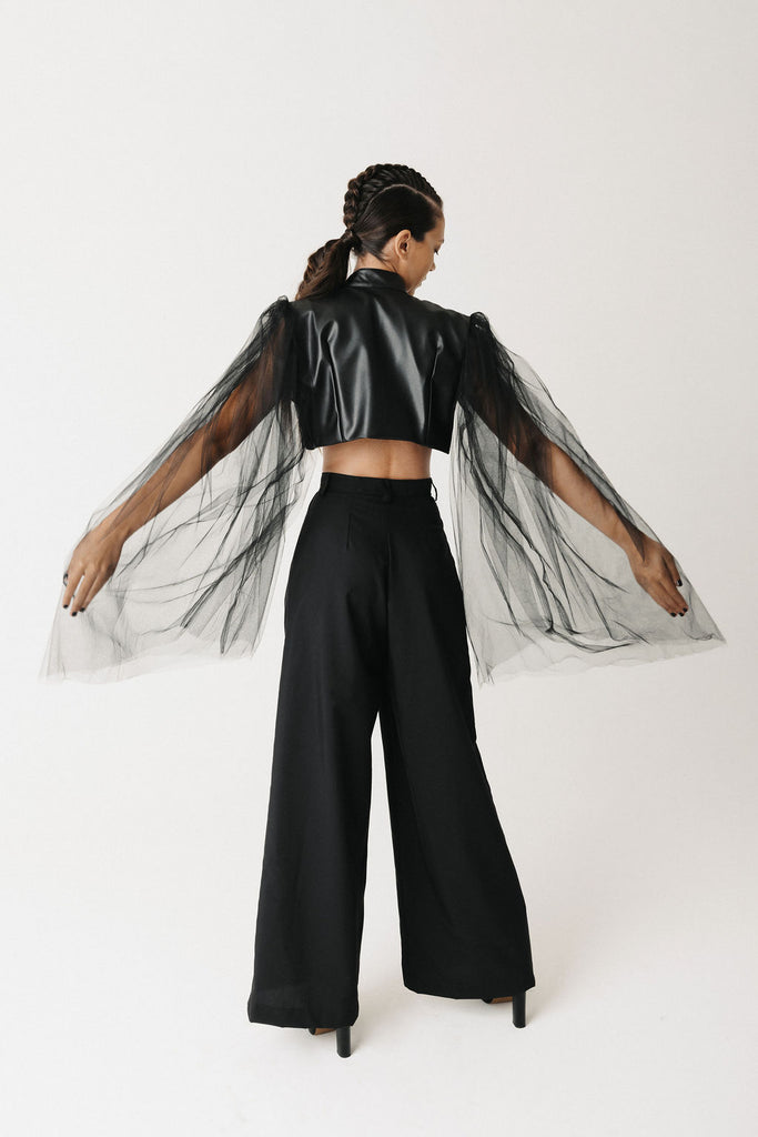 Video of model wearing black cactus leather cropped bolero jacket with sheer tulle balloon sleeves, arms outstretched, front view, side view, back view