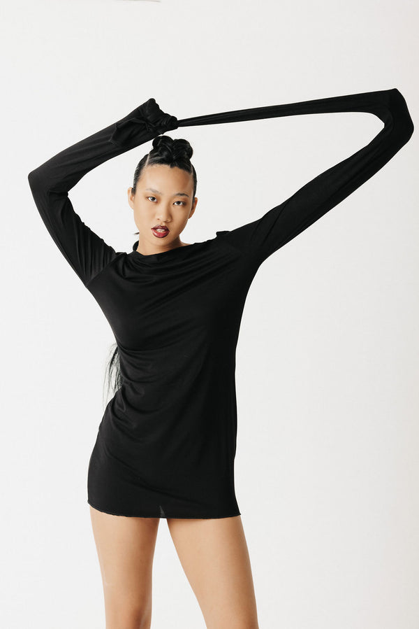 Video of model showing jersey black shirt with extra long sleeves styled as a mini dress showing front, side, and back view