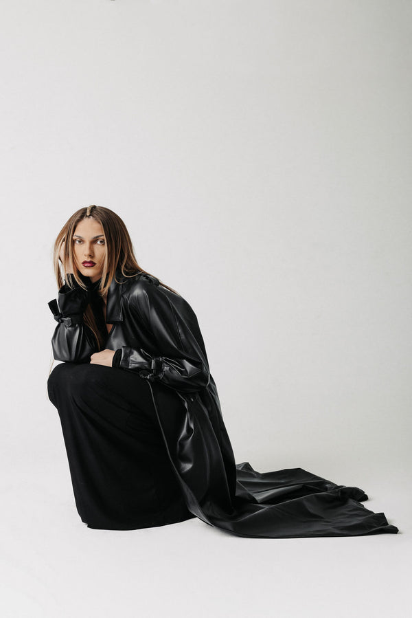 Video of model wearing a cactus leather black trench coat and black maxi dress showing front, side, and back view of the coat