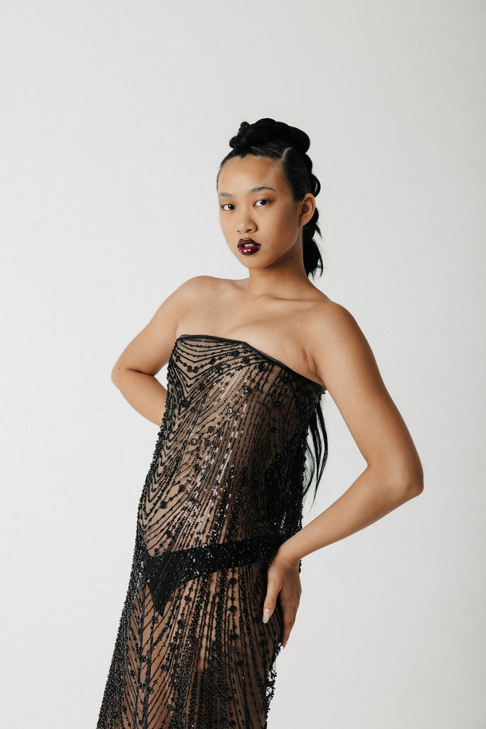 Video of model showing front, side, and back view of a beaded, strapless dress with a corset base and lace up back