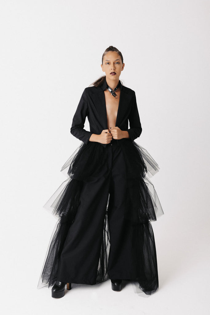 Model wears black cotton blazer with eco tulle train. She wears it with cotton wide leg pants. Shows front view, side view, back view, and close up.