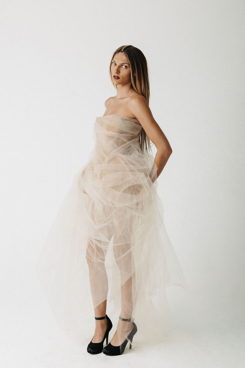 Model wearing strapless nude eco-tulle gown with structured corset, side view