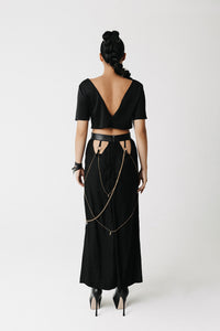 Back view of the Penance Skirt showing draped chains and gold cross charms against the cutout waistband