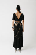 Back view of the Penance Skirt showing draped chains and gold cross charms against the cutout waistband