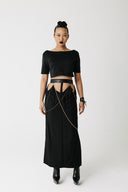 Model wearing the Penance Skirt, an organic bamboo cotton maxi skirt with cactus leather waistband and draped gold chains