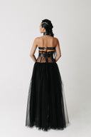 Model wearing The Tomyris Skirt, a black eco-tulle skirt with boned corset waistband back view