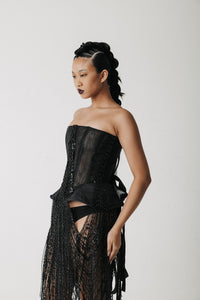 Close-up of the Boudica Gown's corset bodice showing the hand-beaded fringe and structured peplum points
