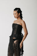 Close-up of the Boudica Gown's corset bodice showing the hand-beaded fringe and structured peplum points