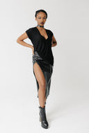 Front view of model wearing the Void Tee, a black jersey V-neck tee with a draped asymmetric hem, styled with a cactus leather skirt 