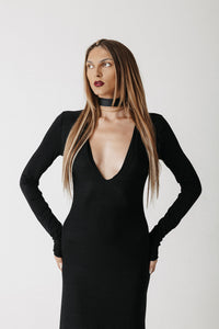 Front view close up of model wearing the Hollow Dress, a black jersey maxi dress with a low V neckline, styled with a choker sold separately