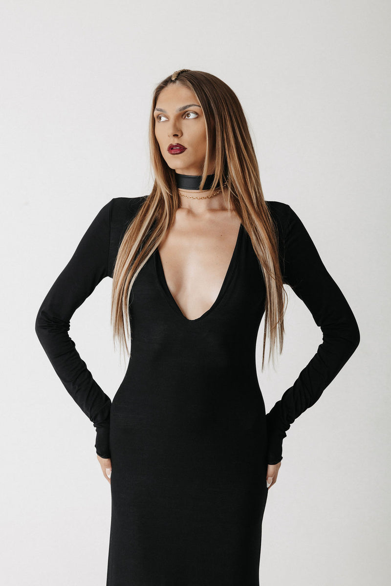 Front view close up of model wearing the Hollow Dress, a black jersey maxi dress with a low V neckline, styled with a choker sold separately