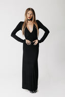 Front view of model wearing the Hollow Dress, a black jersey maxi dress with a low V neckline, styled with a choker sold separately