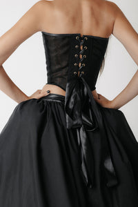 Back view of lace up black corset with full gathered skirt.