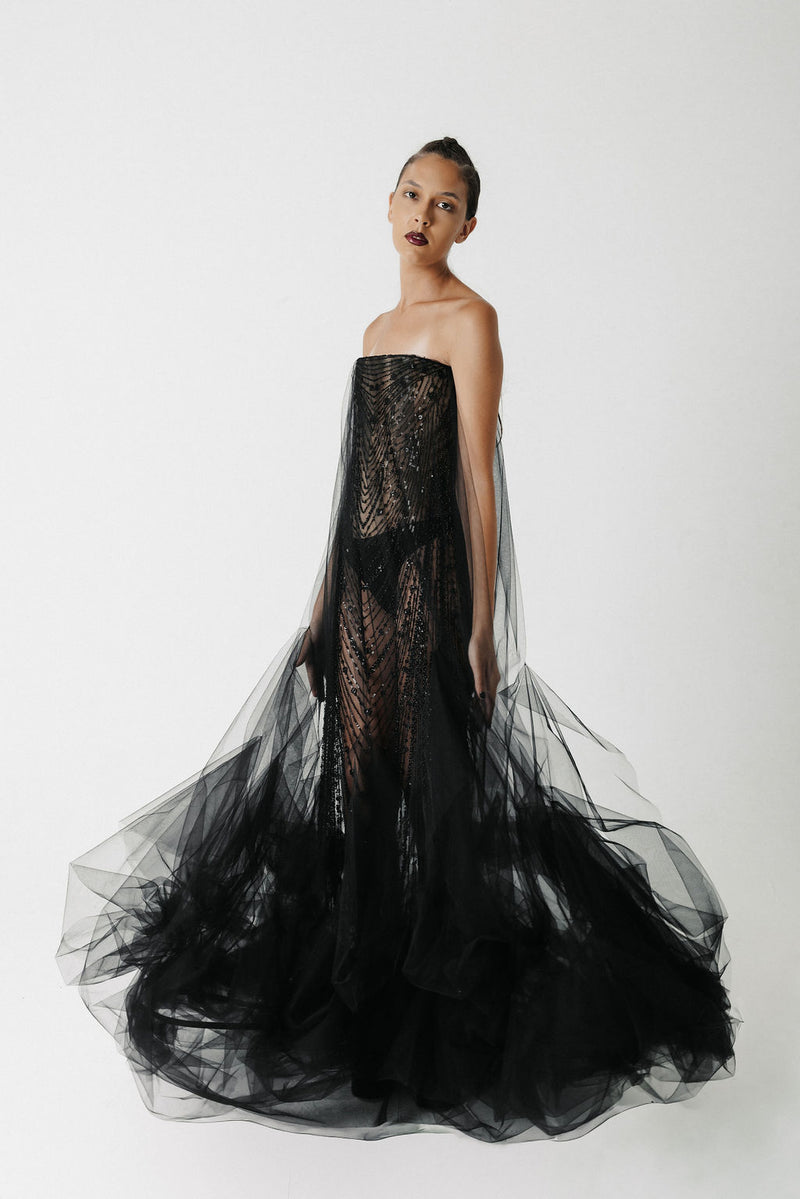 The Hatshepsut Gown side view showing the sheer tulle cape trailing from the shoulder into a voluminous pooled hem