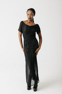 Model wearing black hand-beaded sheer chiffon gown, full length, with platform boots